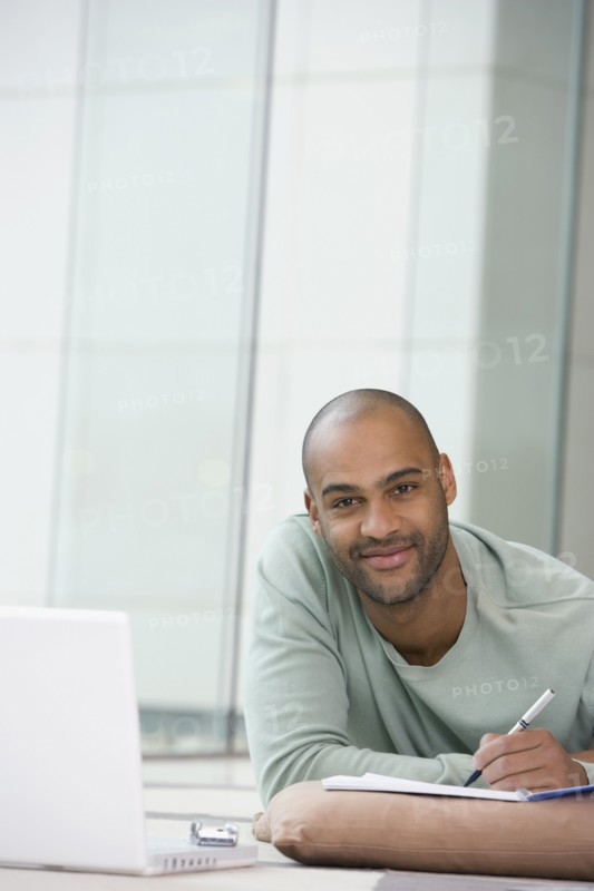 African man writing on notepad