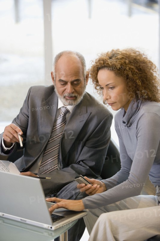 African businesspeople looking at laptop