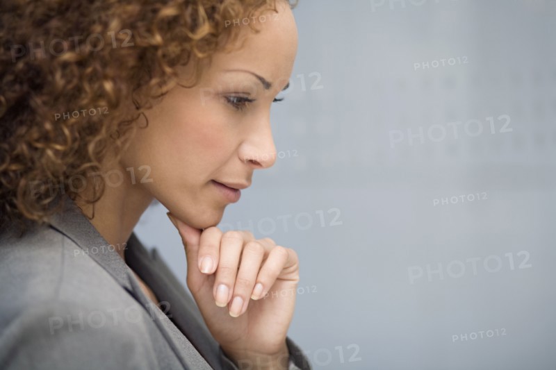 African businesswoman resting chin on hand