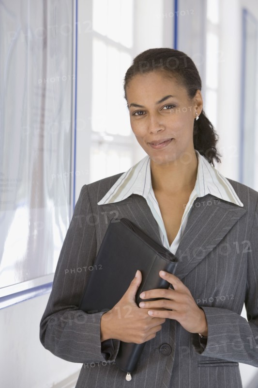 African businesswoman holding binder