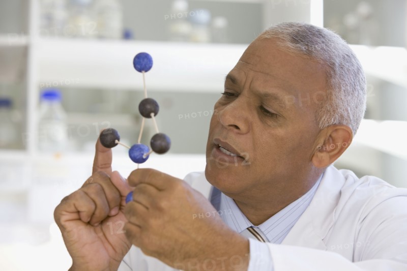 African scientist viewing molecule model in laboratory