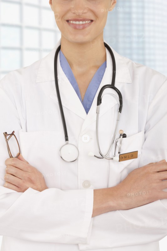 Mixed race doctor with arms crossed in hospital