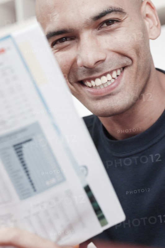 Smiling man reading magazine