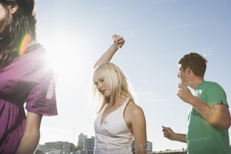 Caucasian friends dancing outdoors