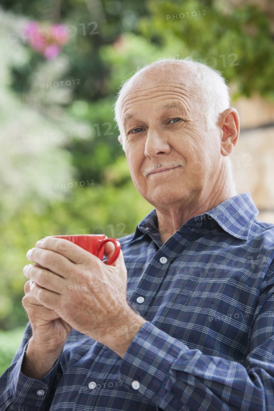 Senior Caucasian man having cup of coffee outdoors