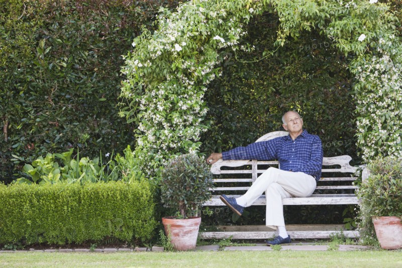 Senior Caucasian man sitting on garden bench