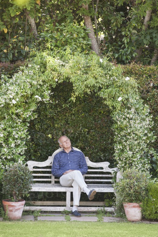 Senior Caucasian man sitting on garden bench