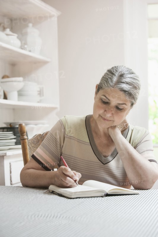 Caucasian woman writing in journal