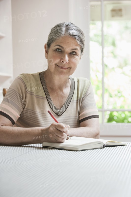 Caucasian woman writing in journal