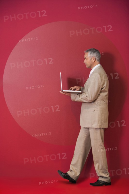 Businessman walking with laptop