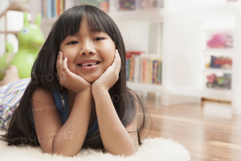 Chinese girl laying with chin in hands