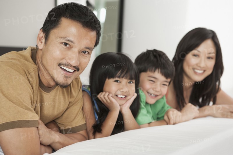 Family laying together on bed
