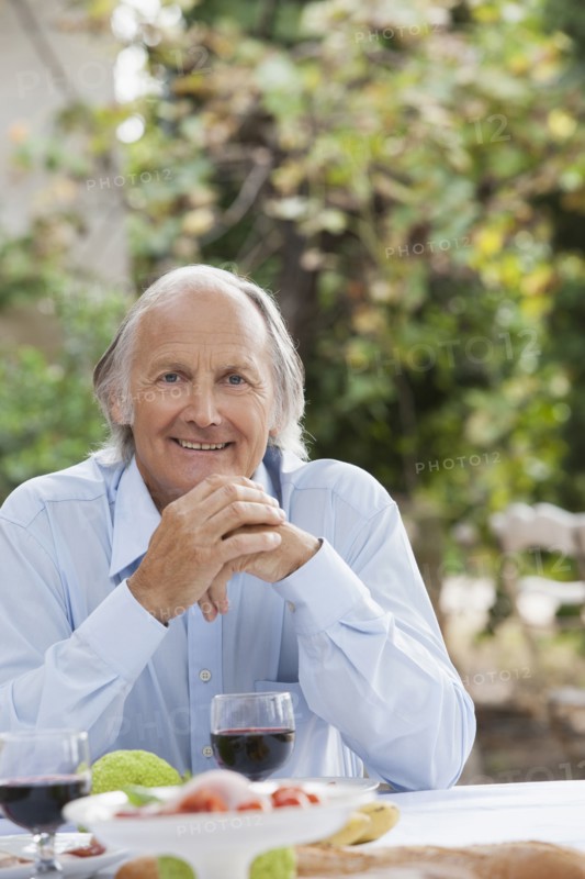 Man eating at table outdoors