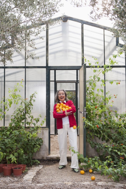 Woman harvesting fruit in greenhouse