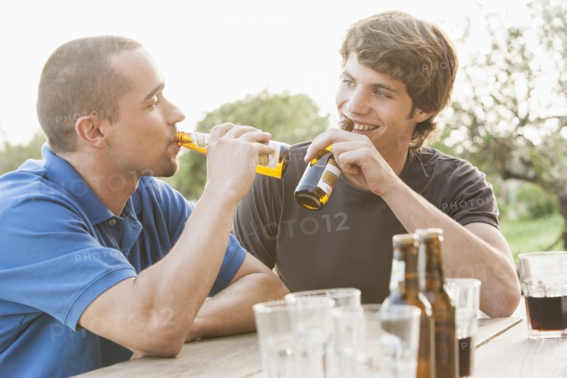 Men drinking beer together outdoors