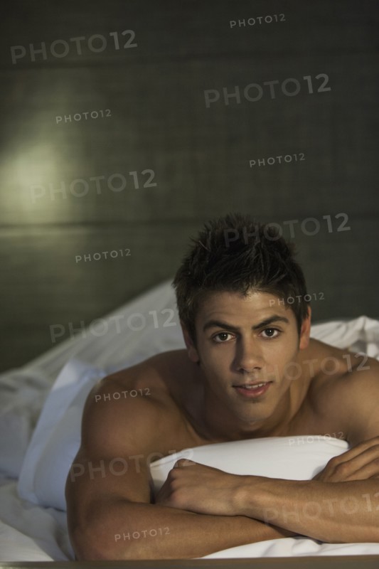Caucasian man relaxing in bed