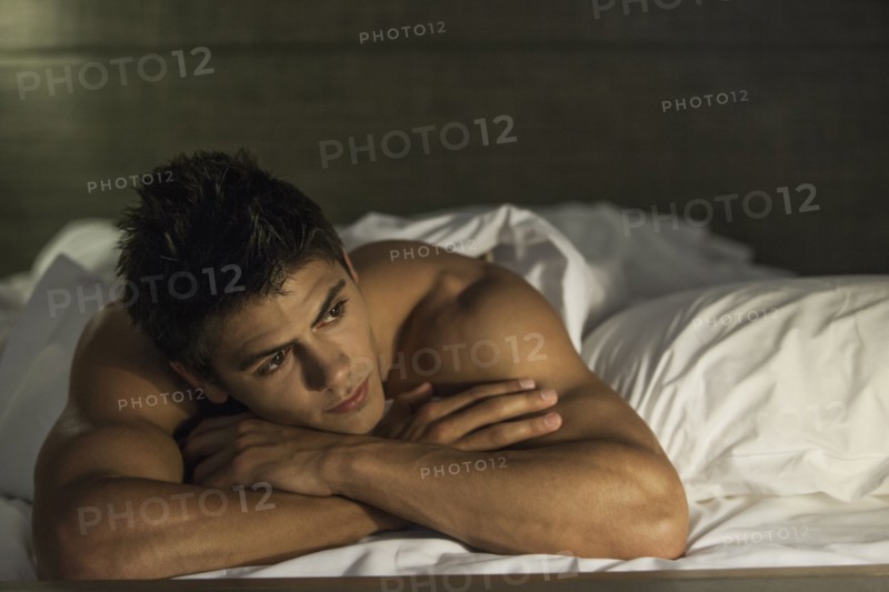 Caucasian man relaxing in bed