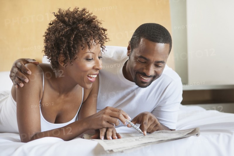 African American couple reading in bed