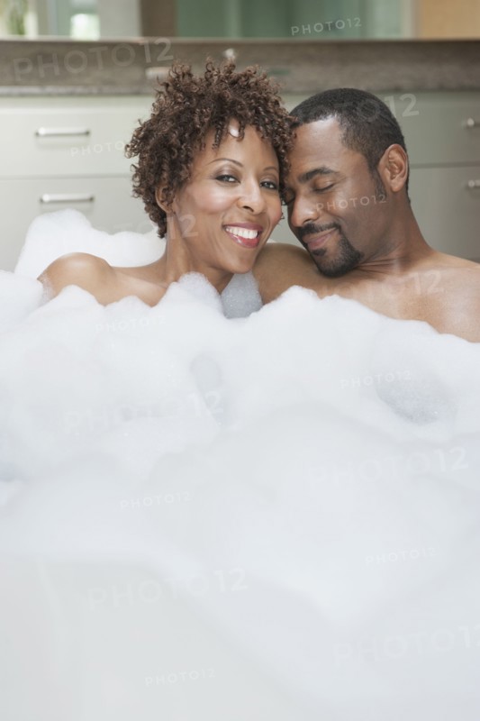 African American couple relaxing in bath
