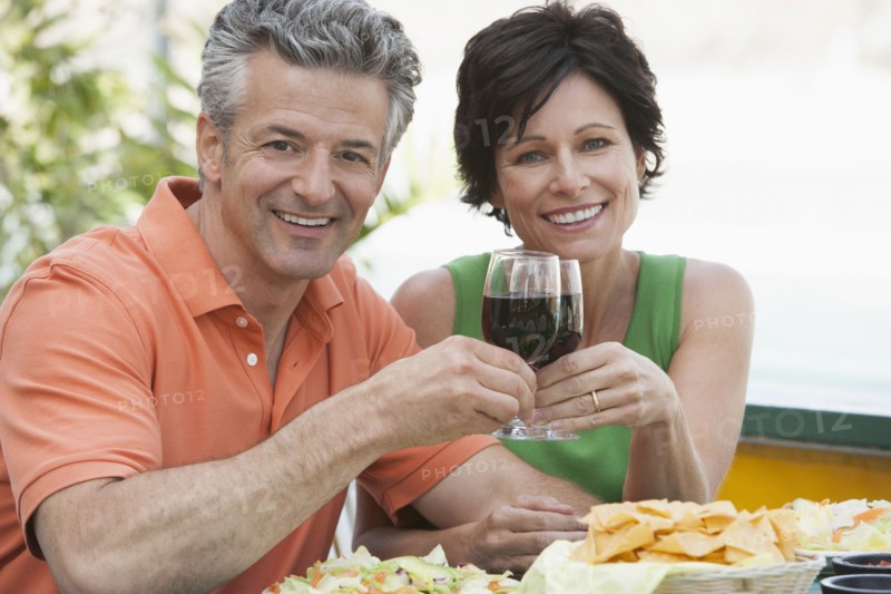 Caucasian couple toasting each other with wine