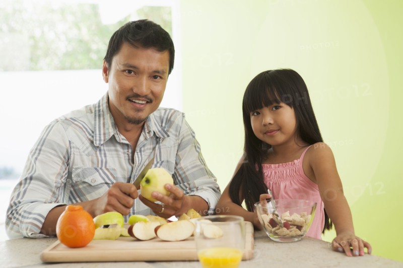 Asian father and daughter having breakfast together