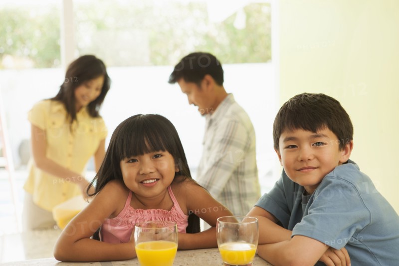Children drinking orange juice at breakfast