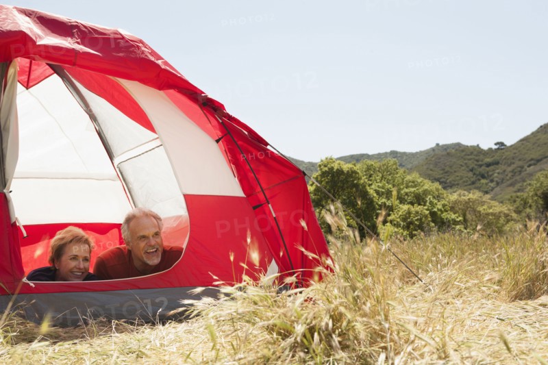 Senior Caucasian couple relaxing in tent