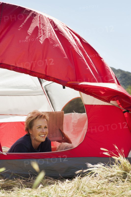 Senior Caucasian woman relaxing in tent