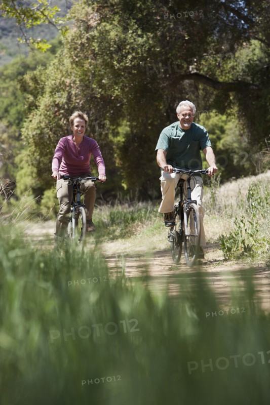 Senior Caucasian couple riding bicycles on rural path