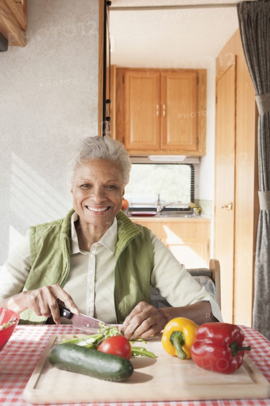 Mixed race Senior woman cooking in RV