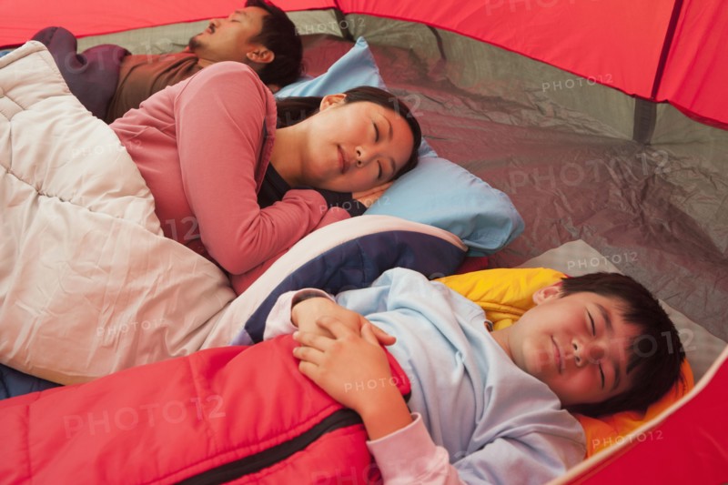 Asian family sleeping in tent