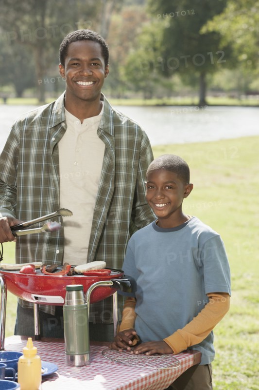 Father and son cooking at picnic table