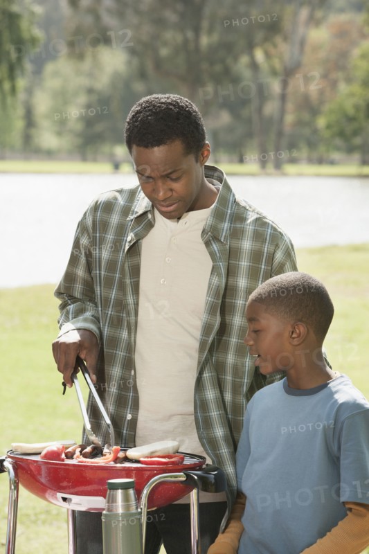 Father and son cooking at picnic table