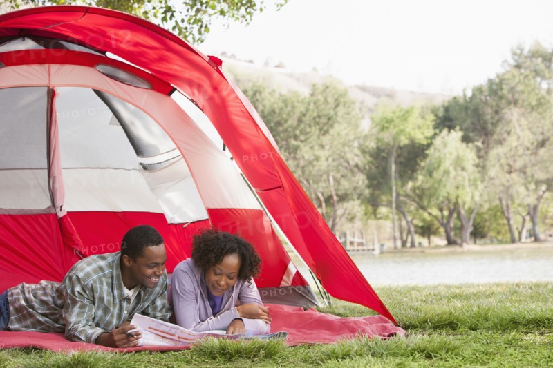 Couple reading newspaper together in tent