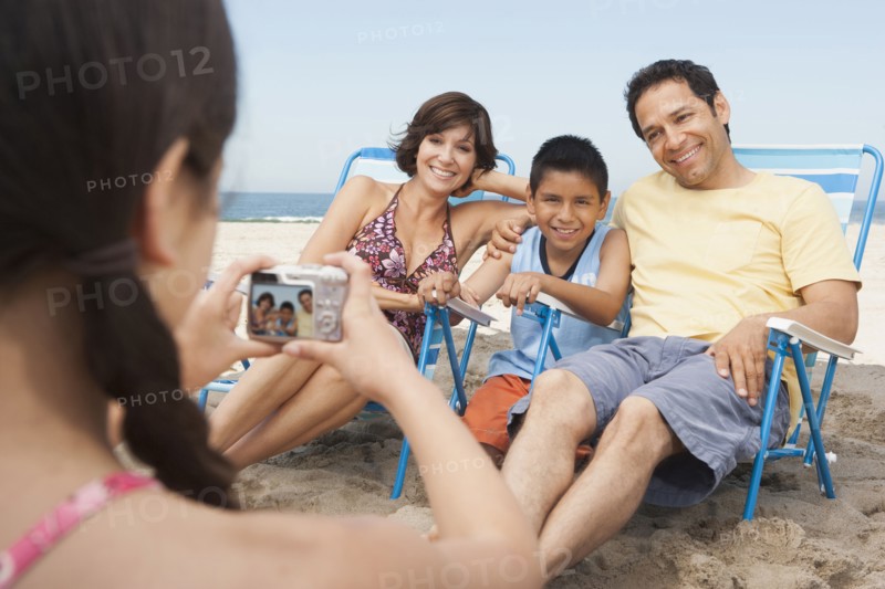 Family taking pictures together on beach