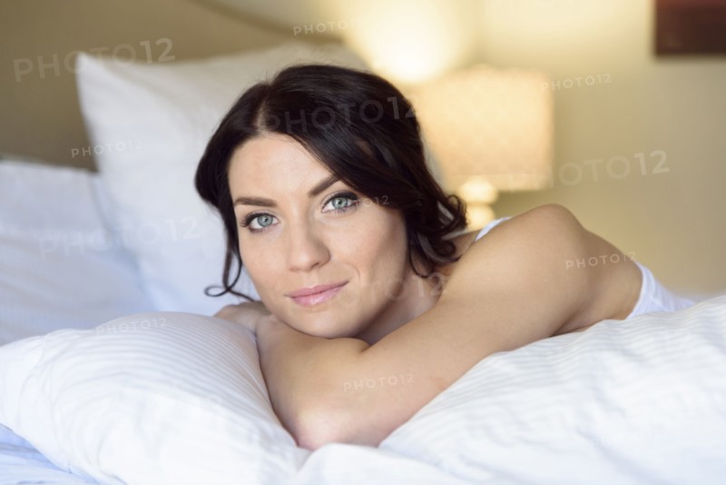 Smiling Caucasian woman laying on bed