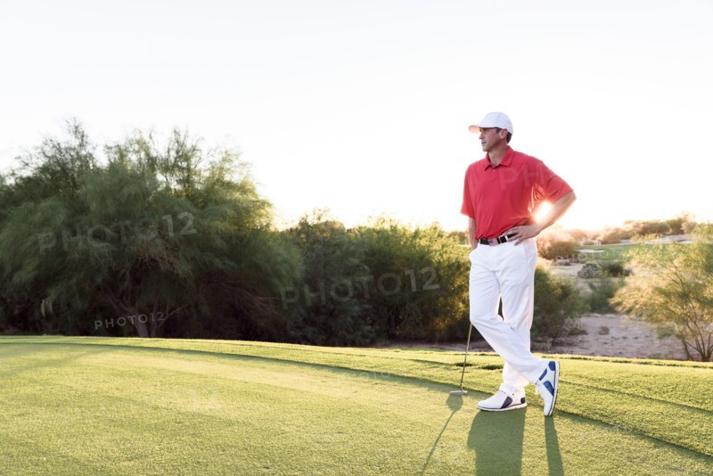 Hispanic golfer waiting on golf course