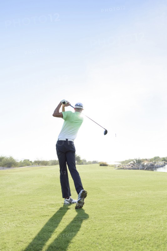 Caucasian man teeing off on golf course