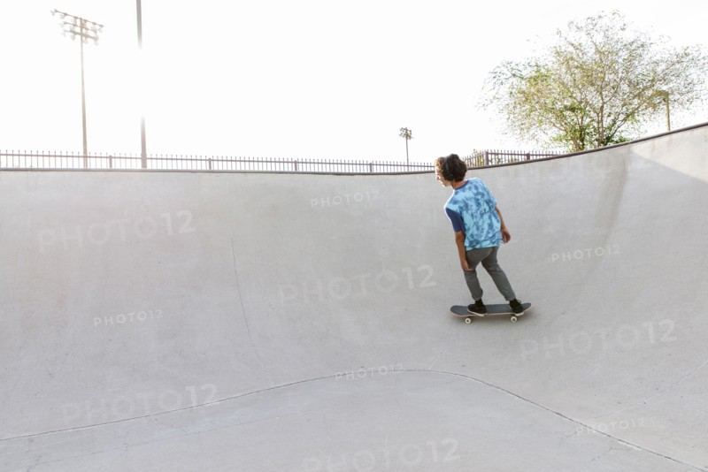 Hispanic man riding skateboard on ramp