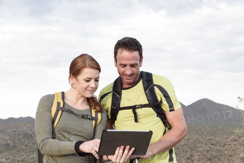 Hikers using digital tablet in desert