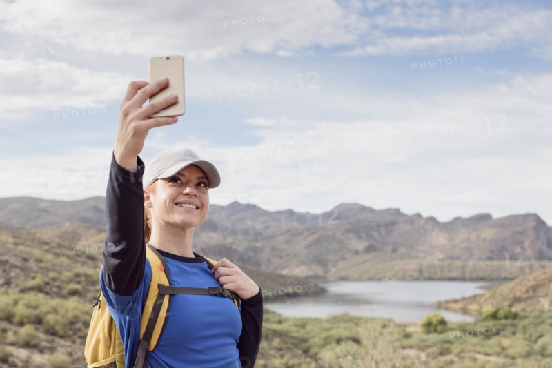 Caucasian woman posing for cell phone selfie in desert