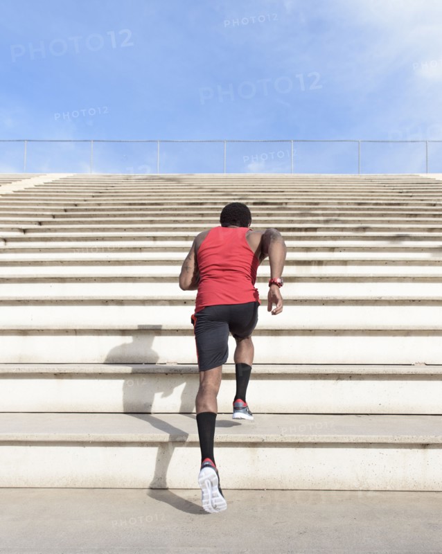 African American man running on bleachers
