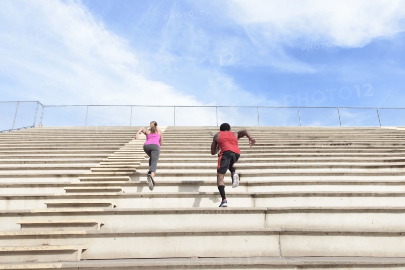 Man and woman running on bleachers