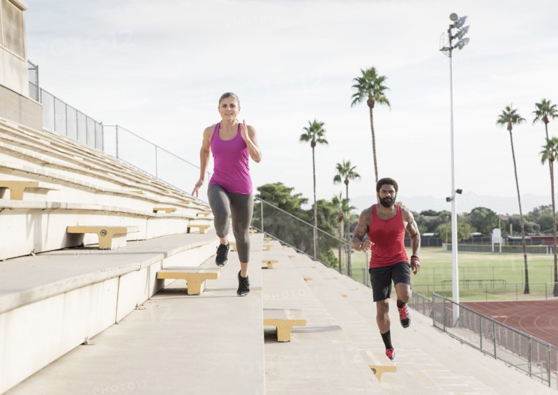 Man and woman running on bleachers