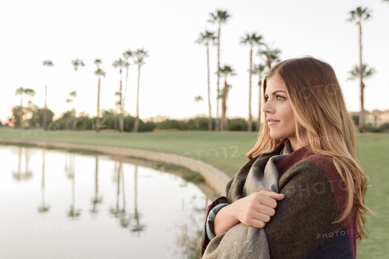 Pensive Hispanic woman near lake