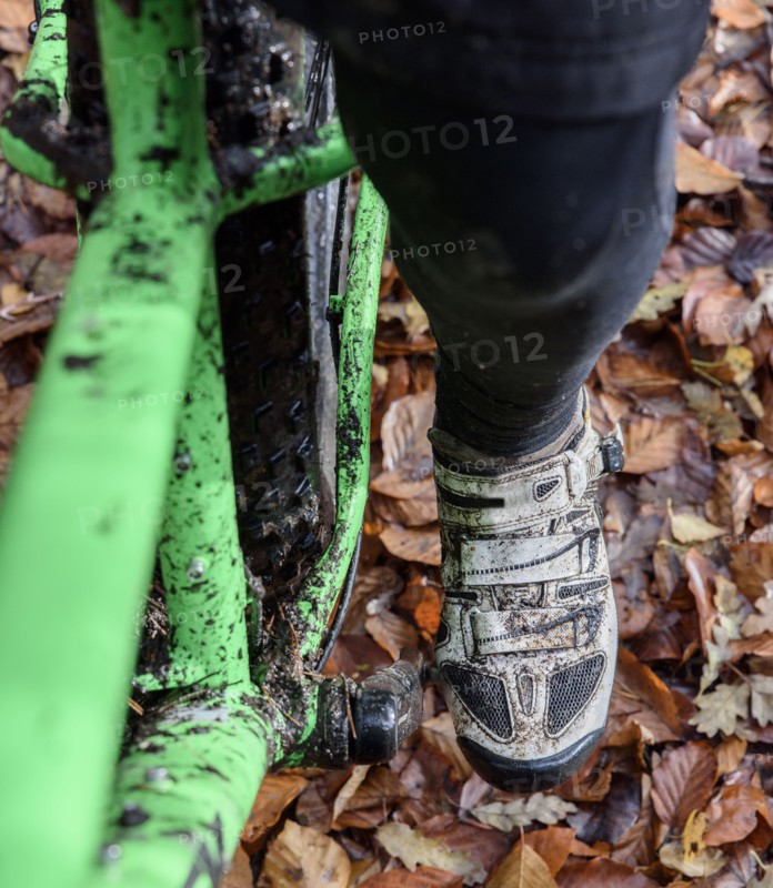 Leg of Caucasian woman riding bicycle in autumn leaves
