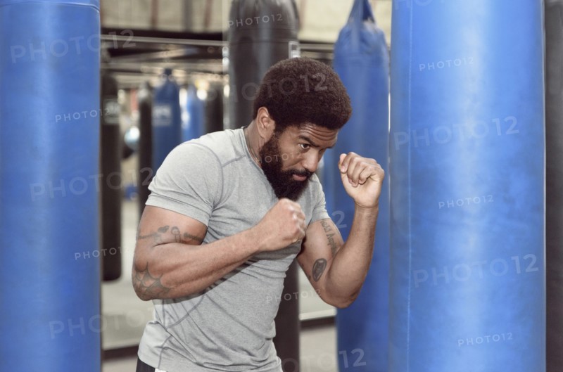 Black man using punching bag