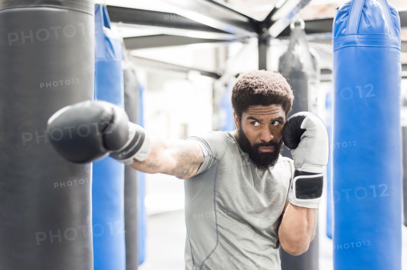 Portrait of Black man wearing boxing gloves in gymnasium