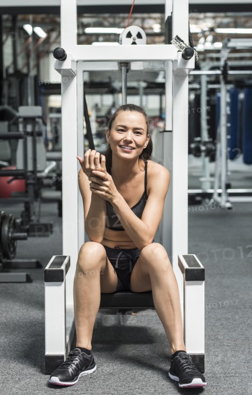 Mixed race woman rubbing wrist in gymnasium