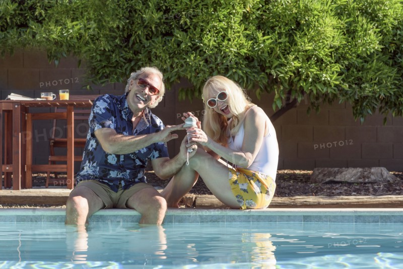 Caucasian couple smiling near swimming pool